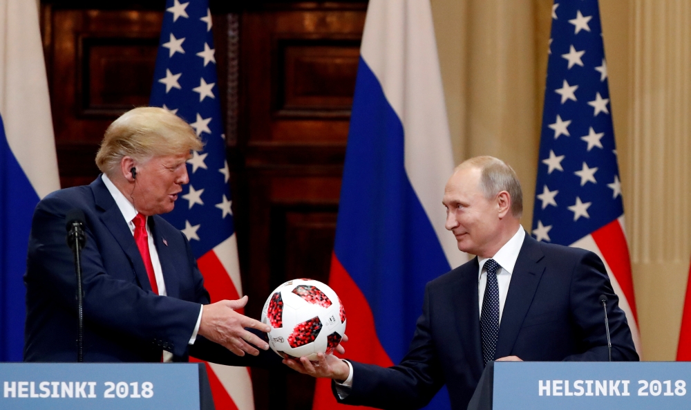 US President Donald Trump receives a football from Russian President Vladimir Putin as they hold a joint news conference after their meeting in Helsinki, Finland July 16, 2018. REUTERS/Grigory Dukor/File Photo