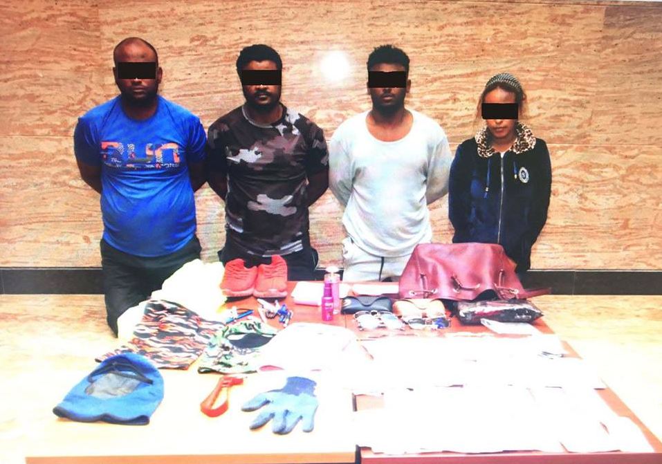 The four members of the gang with confiscated cash and equipment. (PIC: MoI) 