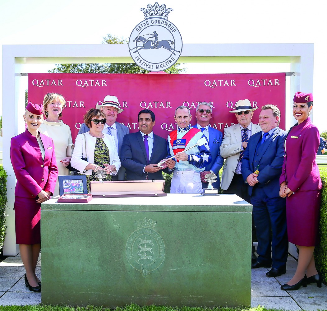 Khalid Al Ali, Qatar Racing & Equestrian Club (QREC) Board Member presenting the winning trophy to a jockey during day four of the Qatar Goodwood festival in Goodwood, West Essex yesterday. 