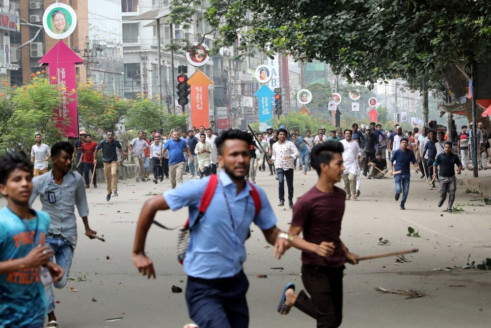 Students run back during clashes with unidentified miscreants while protesting over recent traffic accidents that killed a boy and a girl, in Dhaka, Bangladesh, August 4, 2018. (REUTERS/Mohammad Ponir Hossain)