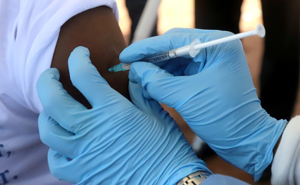 File photo of a World Health Organization (WHO) worker administers a vaccination during the launch of a campaign aimed at beating an outbreak of Ebola in the port city of Mbandaka, Democratic Republic of Congo May 21, 2018. REUTERS/Kenny Katombe/File Phot