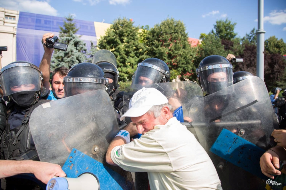 Riot police scuffles with a demonstrator during a protest in Bucharest, Romania August 10, 2018, in this image taken from social media. Picture taken August 10, 2018. Octav Dragan/via Reuters