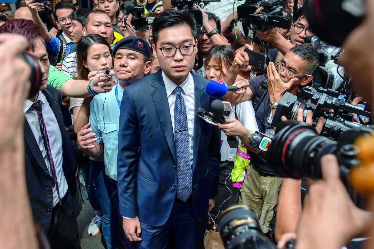 Andy Chan (C), founder of the Hong Kong National Party, is surrounded by members of the media as he leaves the Foreign Correspondents' Club (FCC) in Hong Kong on August 14, 2018. AFP / Philip Fong
 