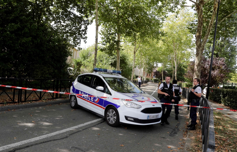 French police officials stand alert as they cordon off a road in Trappes, south-west of Paris on August 23, 2018, following a knife attack. AFP / Thomas SAMSON
