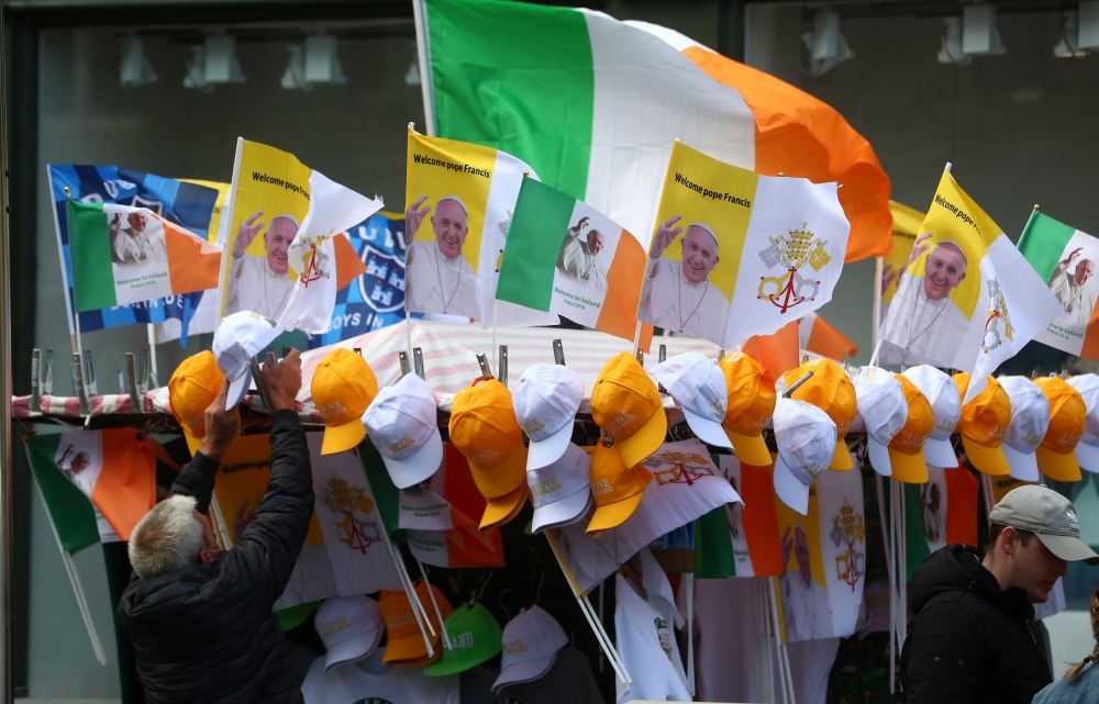 A man sells Pope Francis souvenirs from a stall in Dublin, Ireland August 24, 2018. Reuters/Hannah McKay