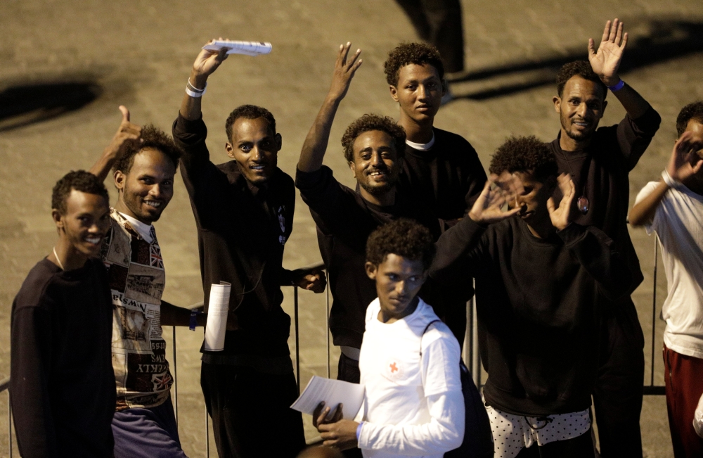  Migrants wave after disembarking from Italian coast guard vessel 