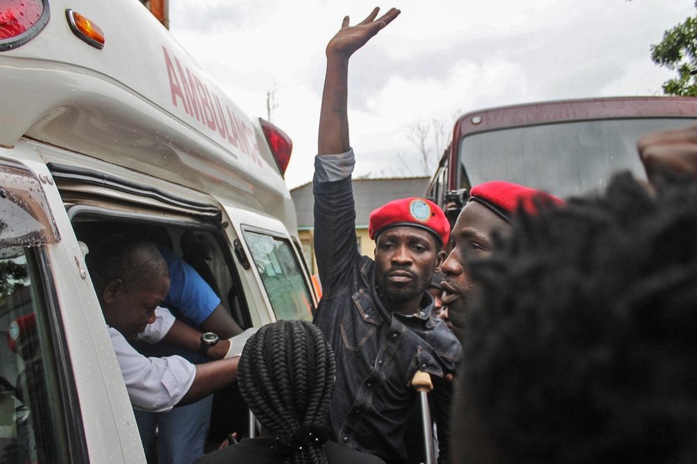 Ugandan singer-turned-politician Robert Kyagulanyi (C), better known as Bobi Wine, reacts as he gets into an ambulance after being released on bail at The High Court in Gulu, northern Uganda, on August 27, 2018.  / AFP / Stringer 