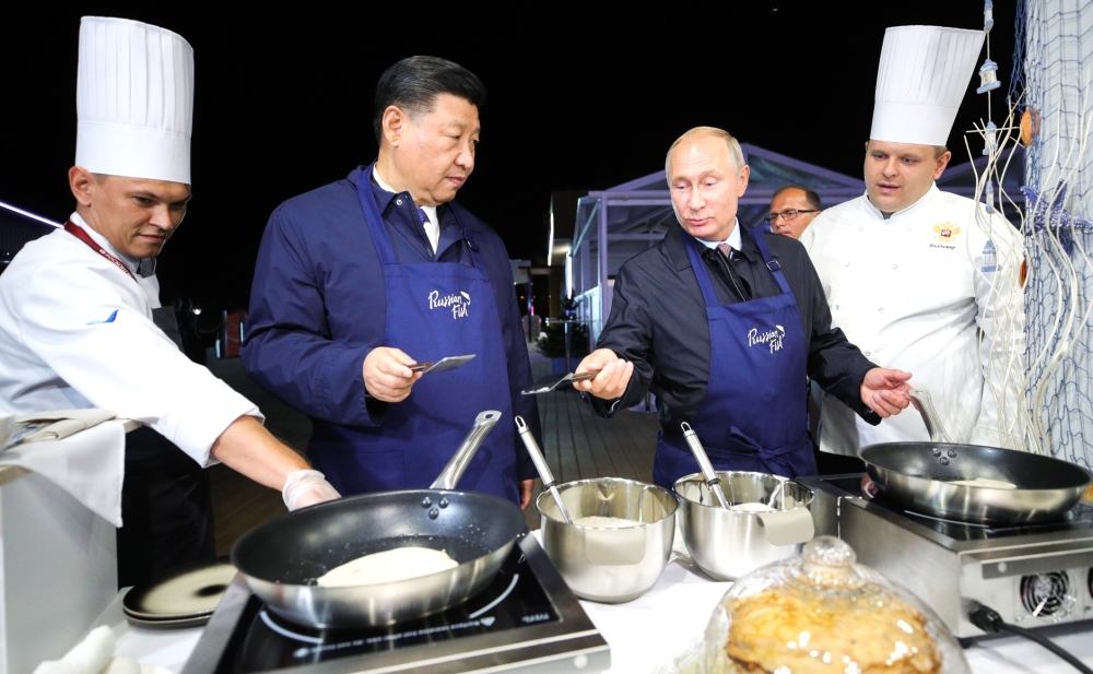 China's President Xi Jinping (2nd L) and Russia's President Vladimir Putin (2nd R) making bliny [Russian pancakes] as they visit the Far East Street exhibition on the sidelines of the 2018 Eastern Economic Forum on Russky Island in Vladivostok, Russia on 