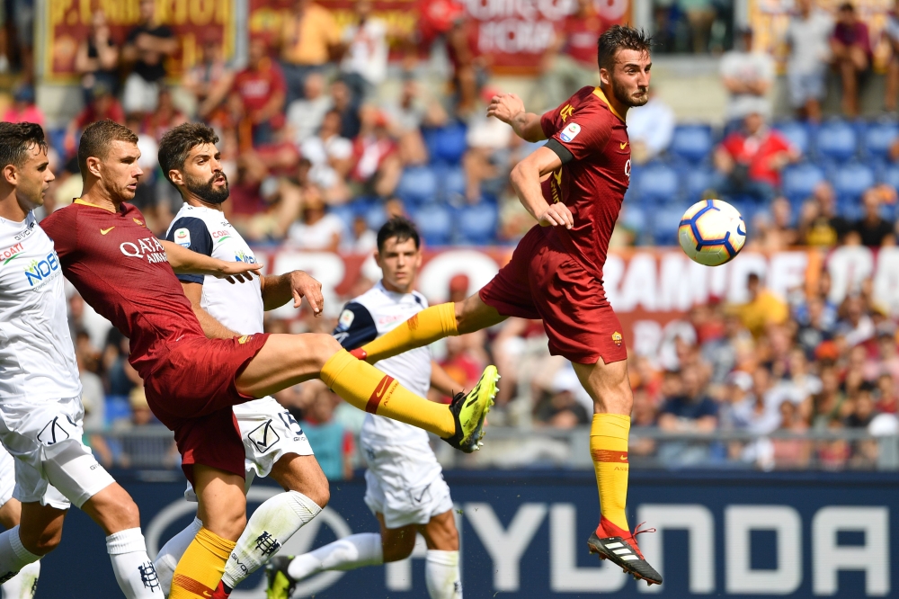 Roma's Italian midfielder Bryan Cristante (R) and Roma's Bosnian forward Edin Dzeko (2ndL) go for the ball during the Italian Serie A football match AS Rome vs Chievo Verona on September 16, 2018 at the Olympic stadium in Rome. / AFP / Alberto PIZZOLI