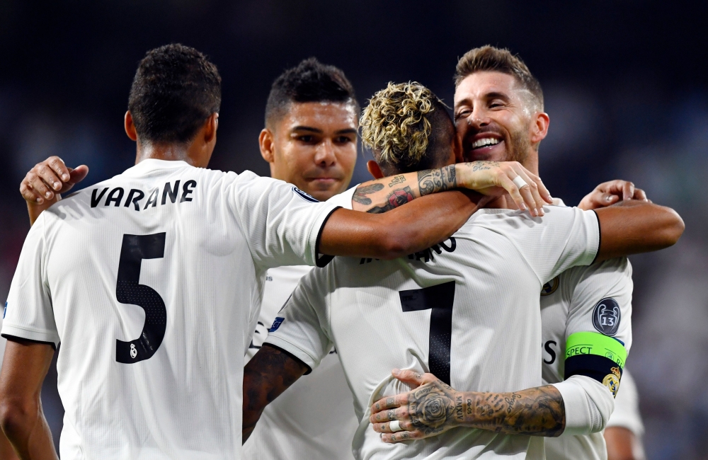 Real Madrid's Spanish-Dominican forward Mariano (2R) celebrates his goal with Real Madrid's Spanish defender Sergio Ramos (R) during the UEFA Champions League group G football match between Real Madrid CF and AS Roma at the Santiago Bernabeu stadium in Ma