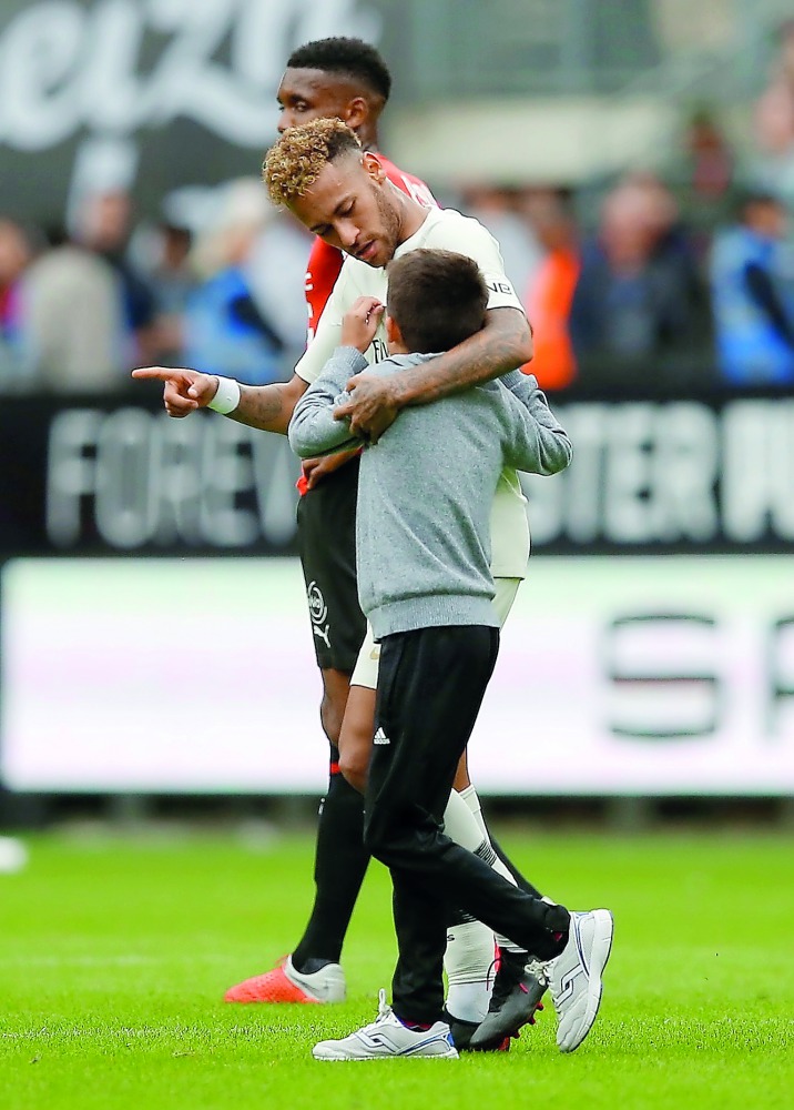 Paris St Germain's Neymar with a pitch invader. Reuters/Stephane Mahe