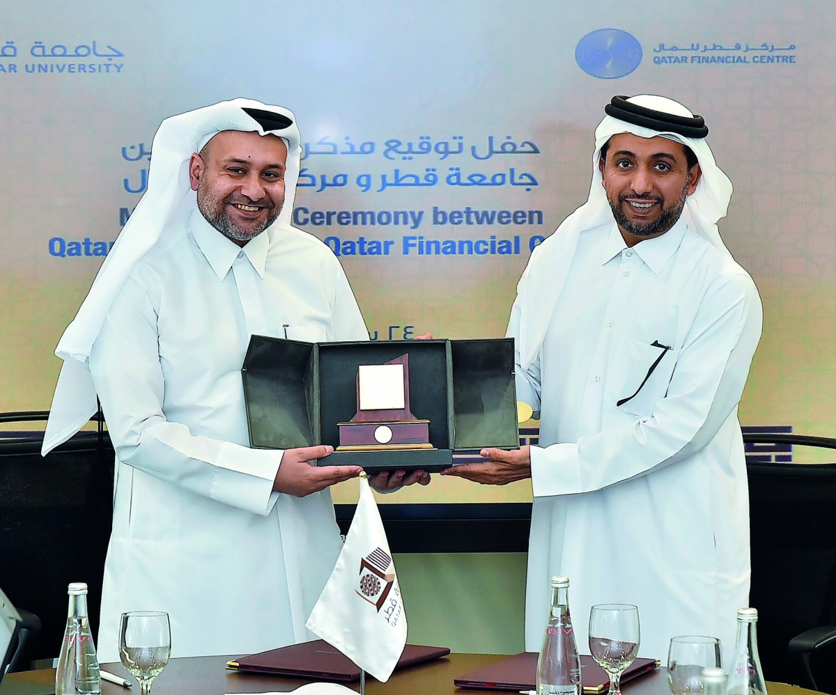 Dr Hassan Al Derham (right), President of Qatar University, and Yousuf Mohamed Al Jaida, Chief Executive Officer and Board Member of QFC, after signing the agreement.