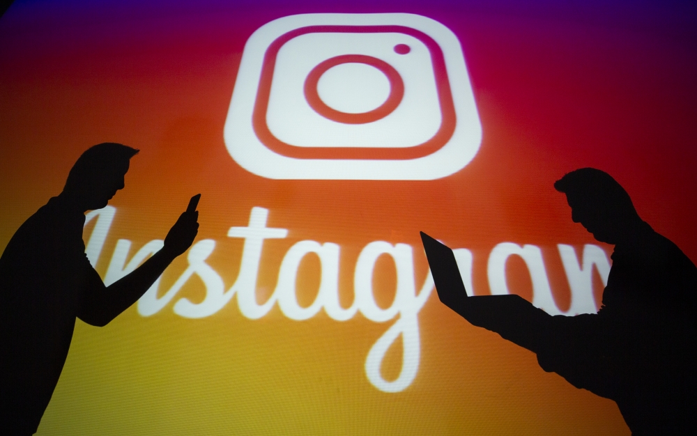 A photo shows silhouttes of men in front of the logo of 'Instagram' social media platform in Ankara, Turkey on September 25, 2018. ( Aytaç Ünal - Anadolu Agency )