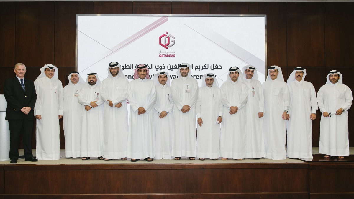 Khalid bin Khalifa Al Thani (sixth left), Qatargas CEO, and senior officials with employees who completed 25 years of service with the company.