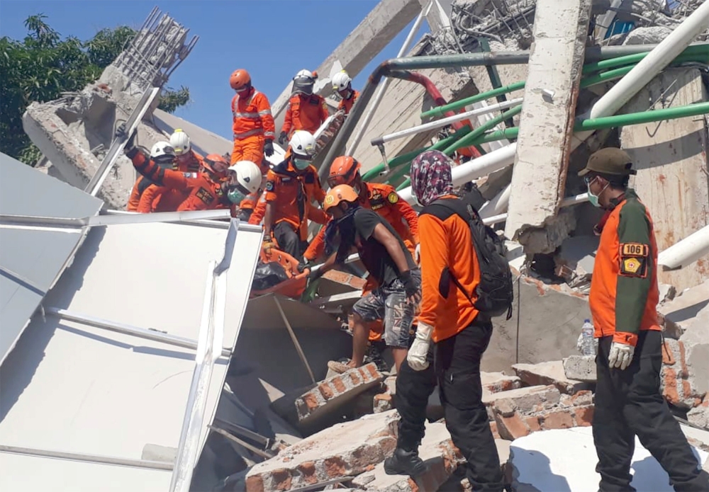 A search and rescue team evacuates a victim from the ruins of the Roa-Roa Hotel in Palu, Central Sulawesi, Indonesia September 30, 2018 in this photo taken by Antara Foto. Antara Foto/BNPB/ via REUTERS 