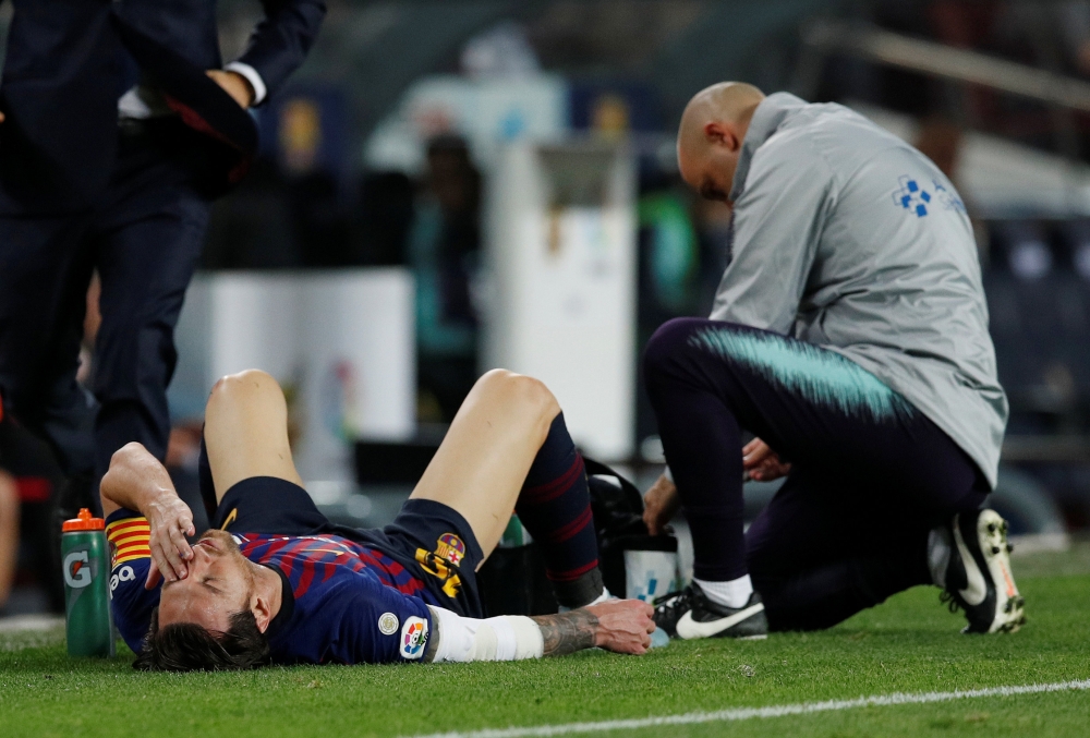 Barcelona's Lionel Messi receives medical attention after sustaining an injury REUTERS/Albert Gea