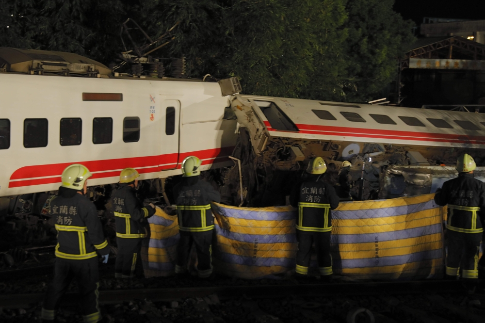 Firefighters and emergency personnel carry on rescue operations after the Puyuma Express train derailed at high speed between Dongshan and Suxin causing at least 18 dead and injuring over 150, in Taiwan's Yilan county on October 21, 2018. / AFP / Daniel M