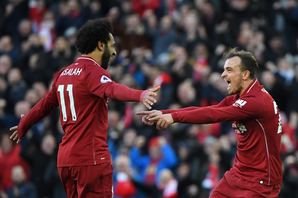 Liverpool's Swiss midfielder Xherdan Shaqiri (R) celebrates scoring their third goal with Liverpool's Egyptian midfielder Mohamed Salah (L) during the English Premier League football match between Liverpool and Cardiff City at Anfield in Liverpool, north 