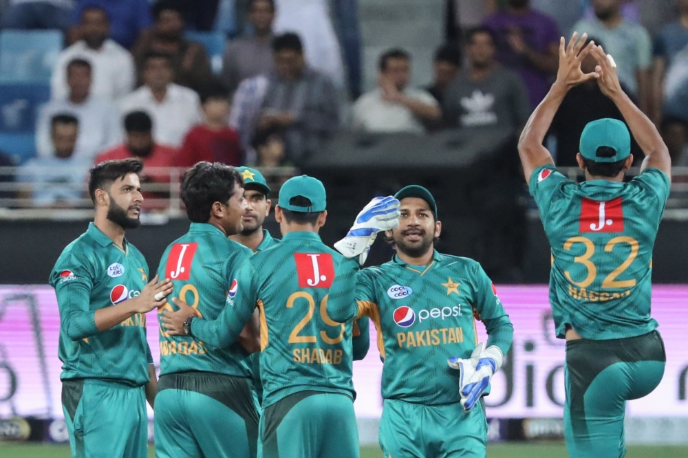 Pakistan's team players celebrate at the end of the T20 cricket match between Pakistan and New Zealand at the Dubai Cricket Stadium in Dubai on November 4, 2018. / AFP / KARIM SAHIB