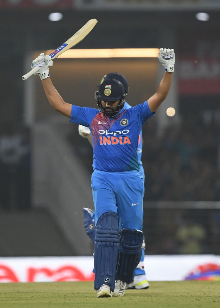 Indian cricket captain Rohit Sharma raises his bat after scoring a century (100 runs) during the second T20 cricket match between India and West Indies at the Bharat Ratna Atal Bihari Vajpayee Ekana Cricket Stadium in Lucknow on November 6, 2018. AFP / Mo