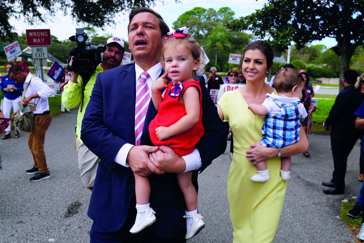Republican candidate for Governor Ron DeSantis arrives to vote, carrying his daughter Madison, in the midterm elections at a polling place, in Ponte Vedra Beach, Florida, yesterday. 