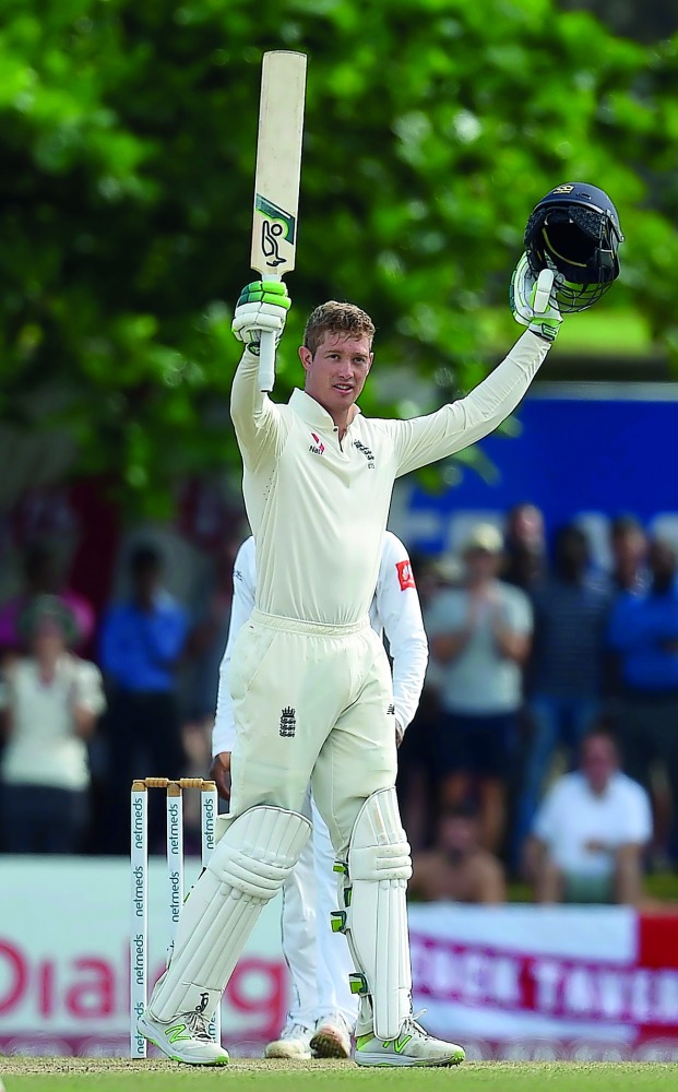 England's Keaton Jennings raises his bat and helmet in celebration after scoring a century (100 runs) during the third day of the opening Test match between Sri Lanka and England at the Galle International Cricket Stadium in Galle on November 8, 2018. AFP