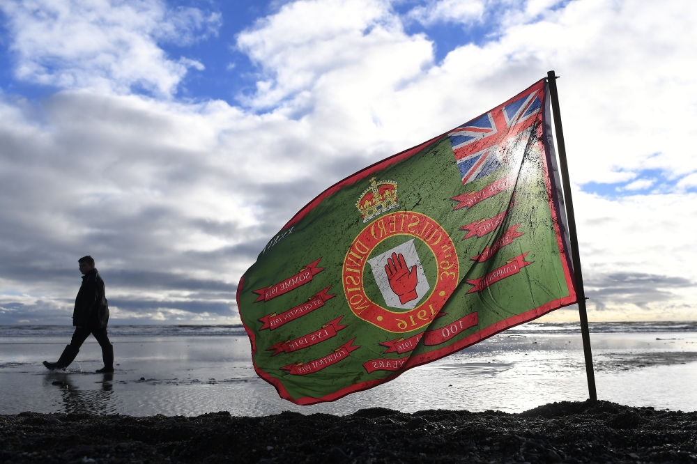 A 100th anniversary flag is seen planted in the sand to remember those killed in World War One, part of Danny Boyle's Pages of The Sea celebrations, on Murlough Beach in Newcastle, Northern Ireland, November 11, 2018. Reuters/Clodagh Kilcoyne