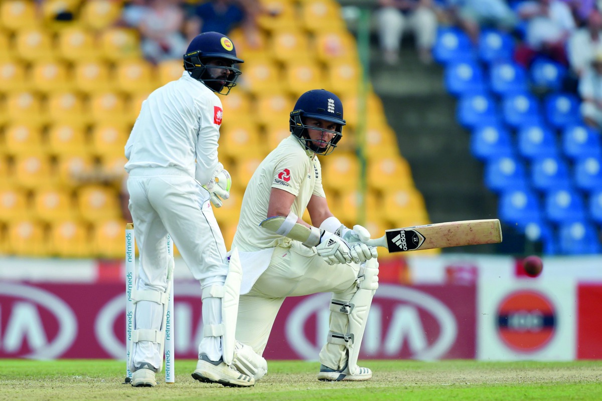 England's Sam Curran (R) plays a shot as Sri Lanka's wicketkeeper Niroshan Dickwella (L) looks on during the first day of the second Test match between Sri Lanka and England at the Pallekele International Cricket Stadium in Kandy on November 14, 2018. AFP