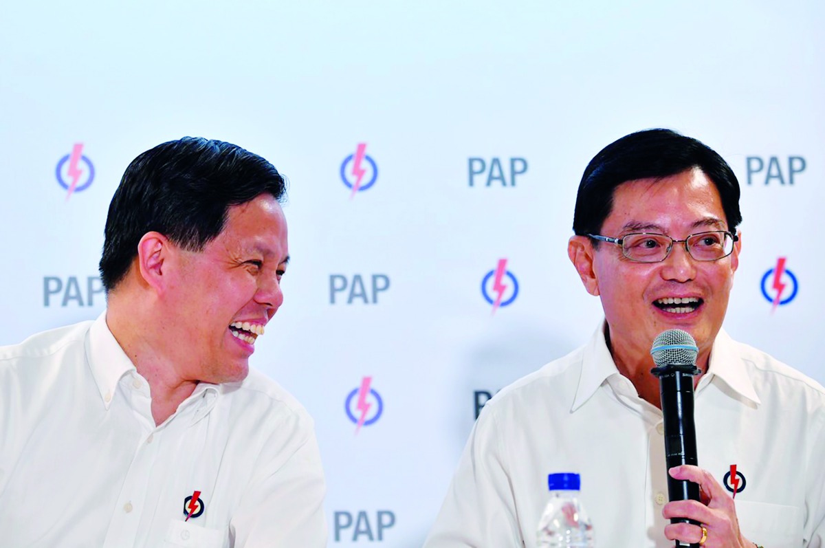 Singapore's Finance Minister Heng Swee Keat (R) speaks as Trade and Industry Minister Chan Chun Sing smiles during a press conference by ruling People Action Party (PAP) in Singapore on November 23, 2018.  AFP /Ariffin Jamar/The Straits Times”  