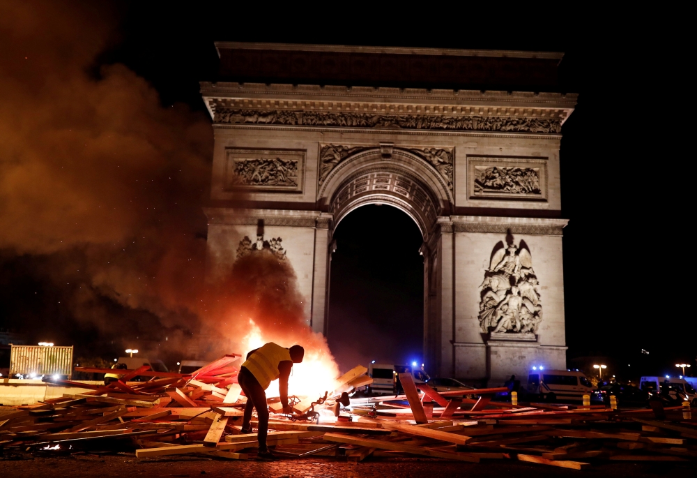 A protester is seen next to a burning barricade during a 