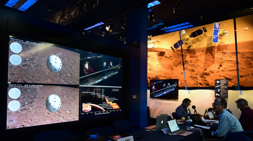 People watch the landing of NASA's InSight spacecraft on the planet Mars on television screens at NASA's Jet Propulsion Laboratory (JPL) in Pasadena, California on November 26, 2018. / AFP / Frederic J. BROWN 