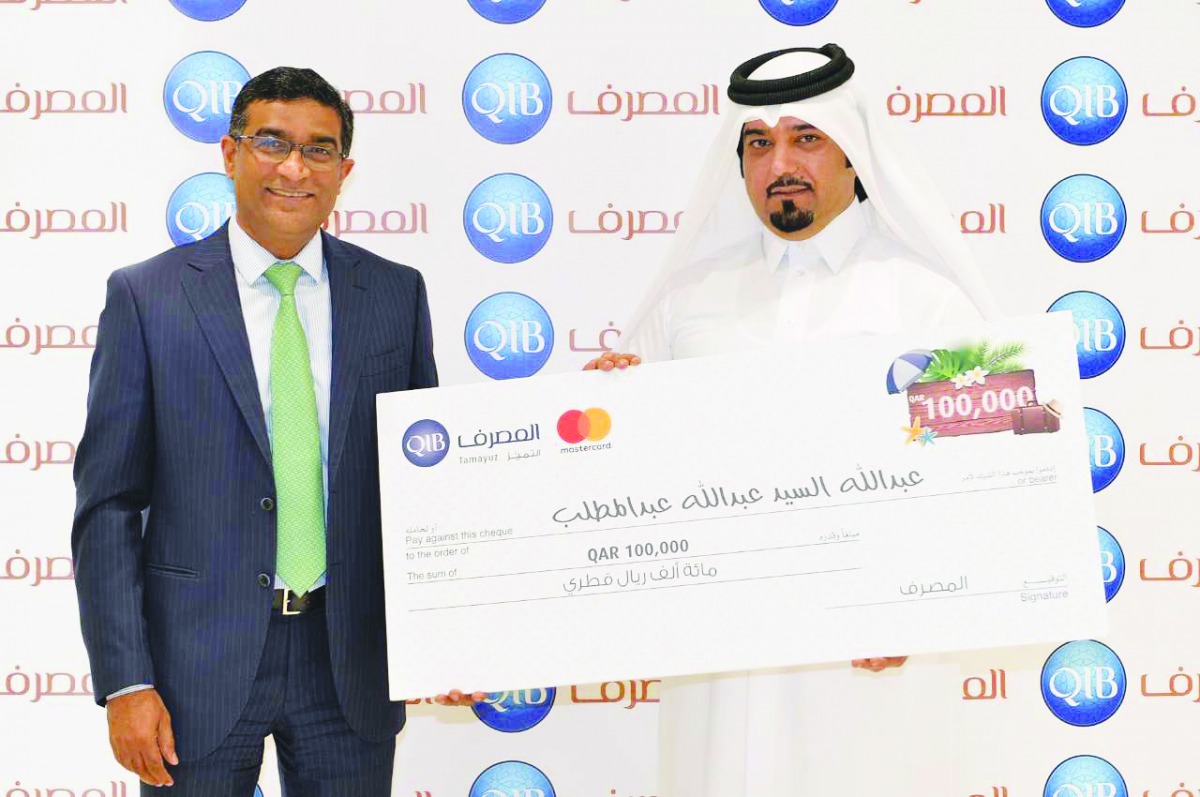 Abdullah Al Sayed (right) receiving the cash prize from QIB’s General Manager-Personal Banking Group, D. Anand.
