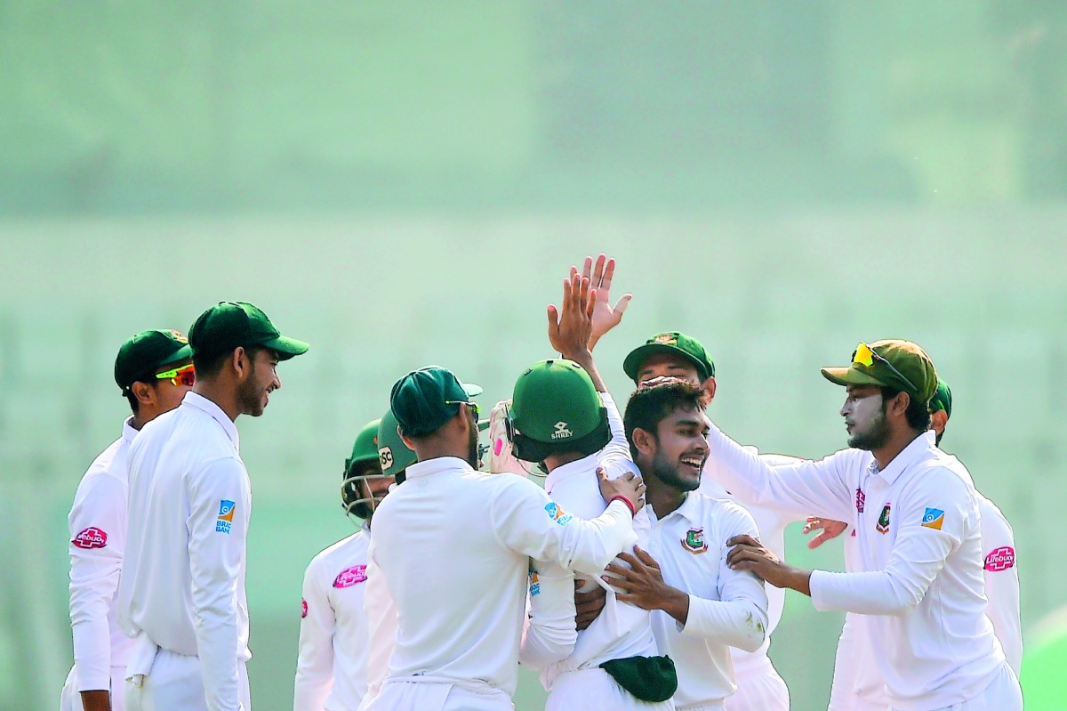 Bangladesh cricketer Shakib Al Hasan (R) congratulate teamamte Mehidy Hasan (2nd R) after the dismissal of the West Indies cricketer Devendra Bishoo during the third day of the second Test cricket match between Bangladesh and West Indies at the Sher-e-Ban