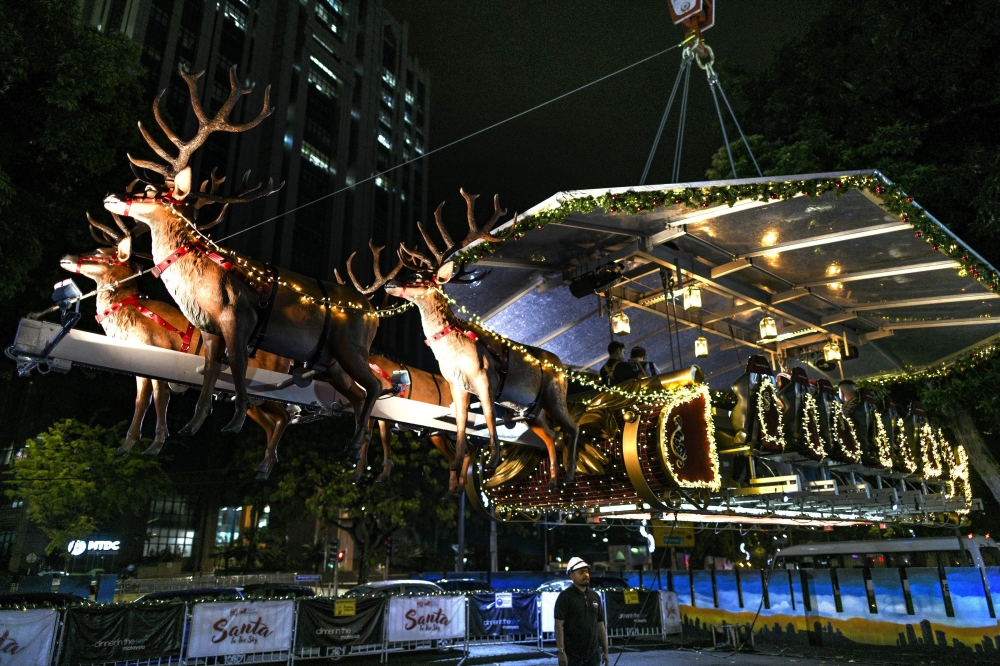 A hanging restaurant being raised by a crane in Kuala Lumpur inspired by Santa Claus travelling on a sleigh with reindeers for a Christmas season promotion on December 5, 2018.  AFP / Mohd Rasfan 