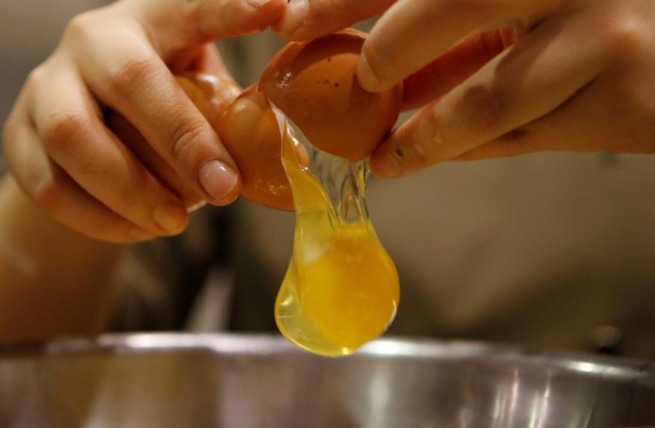 A pastry chef breaks an egg as she prepares to bake a cake at a bakery in Seoul, December 22, 2016. Reuters / Kim Hong-Ji