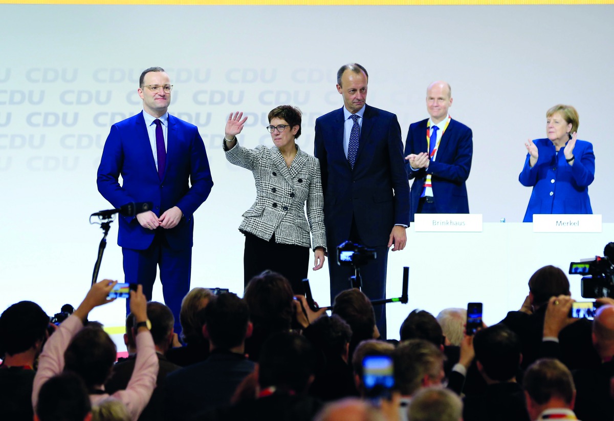 Annegret Kramp-Karrenbauer (C) greets the crowd as she is flanked by candidates for the new leadership of the German Christian Democrats Friedrich Merz (R) and Jens Spahn (L) after elected as new party leader during the 31st Party Congress of the Christia