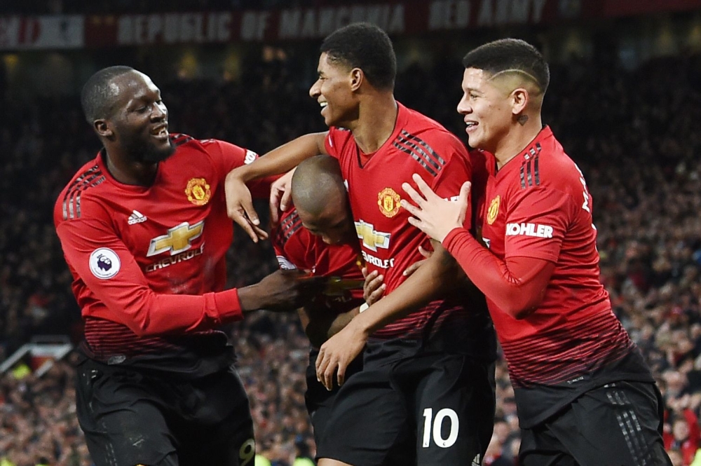 Manchester United's English striker Marcus Rashford celebrates with teammates after scoring their fourth goal during the English Premier League football match between Manchester United and Fulham at Old Trafford in Manchester, north west England, on Decem