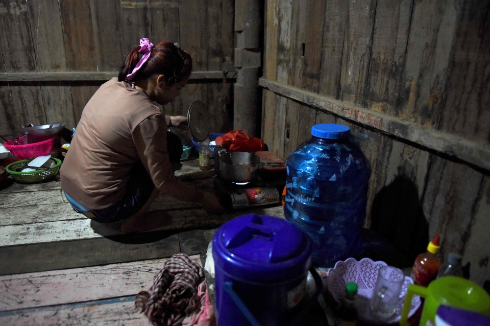 This photo taken on October 2, 2018 shows Nary, a Cambodian victim of forced marriage to a Chinese man, cooking at home in Phnom Penh. AFP / TANG CHHIN Sothy 