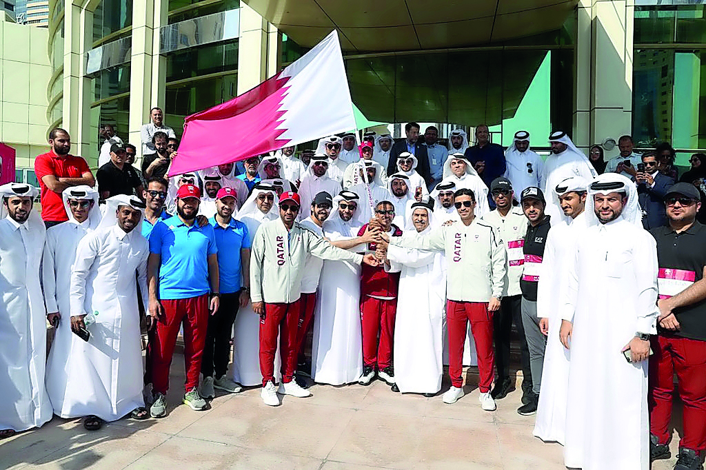 Qatar Olympic Committee (QOC) Vice President Sheikh Saoud bin Ali and QOC Secretary General Jassim Rashid Al Buenain along with other officials receive the national flag outside the QOC headquarters during the second edition of Al Adaam Flag Relay 2018, w