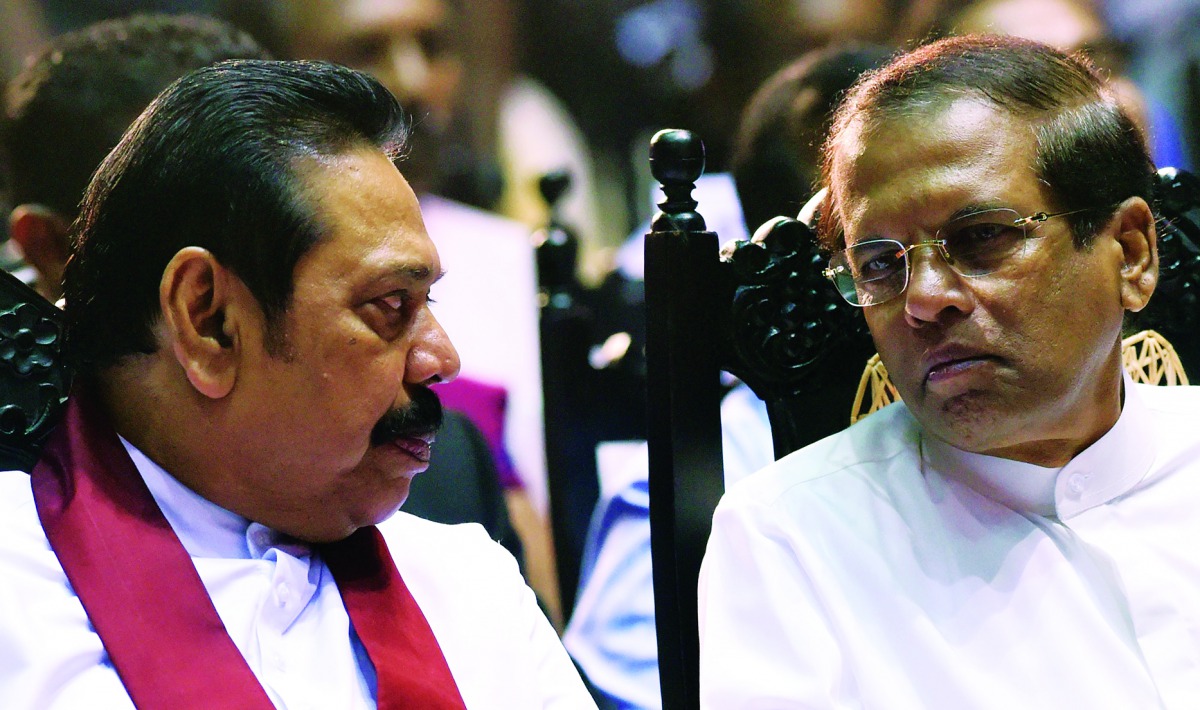 In this file photo taken on November 30, 2018, Sri Lanka’s President Maithripala Sirisena (R) listens to former president and currently-appointed Prime Minister Mahinda Rajapakse attend a ceremony granting employment to social service workers, in Colombo.