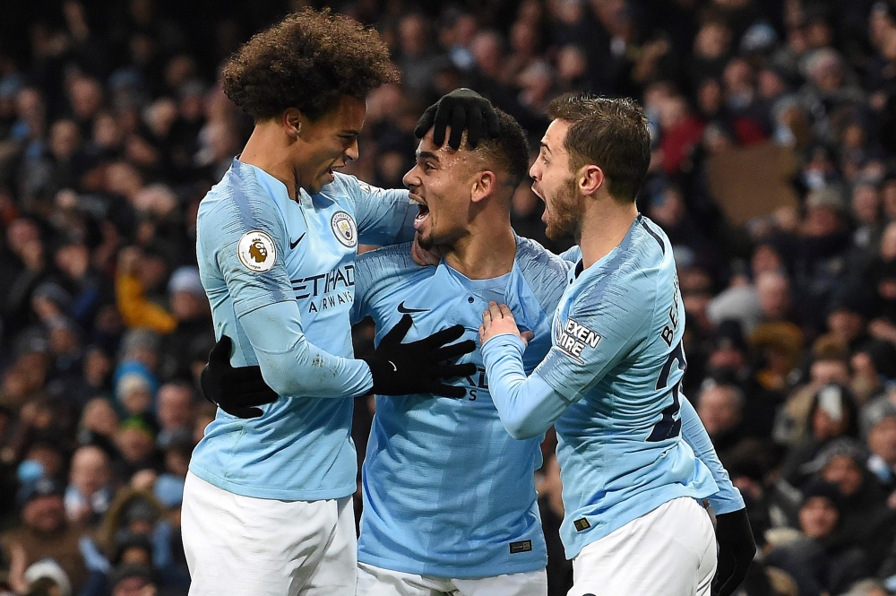 Manchester City's Brazilian striker Gabriel Jesus (C) celebrates scoring his team's first goal with Manchester City's German midfielder Leroy Sane (L) and Manchester City's Portuguese midfielder Bernardo Silva during the English Premier League football ma