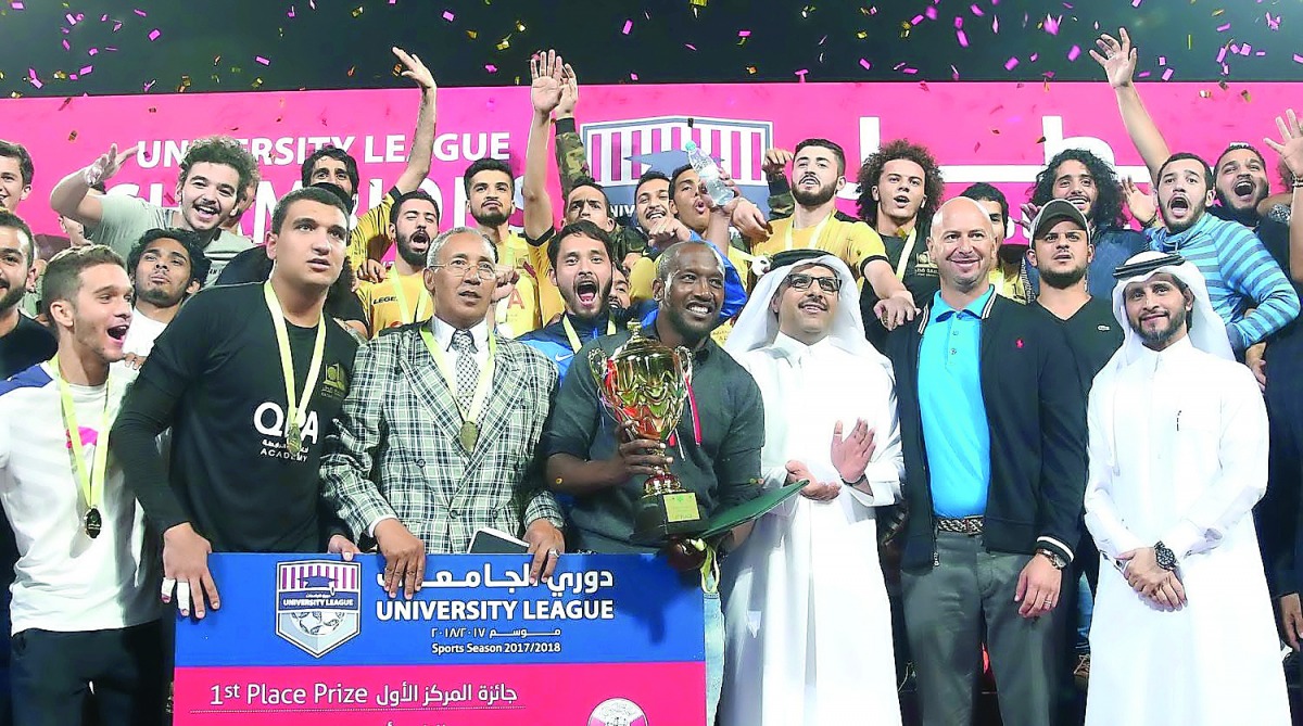 Qatar University’s players and officials celebrate with the trophy after winning the final.