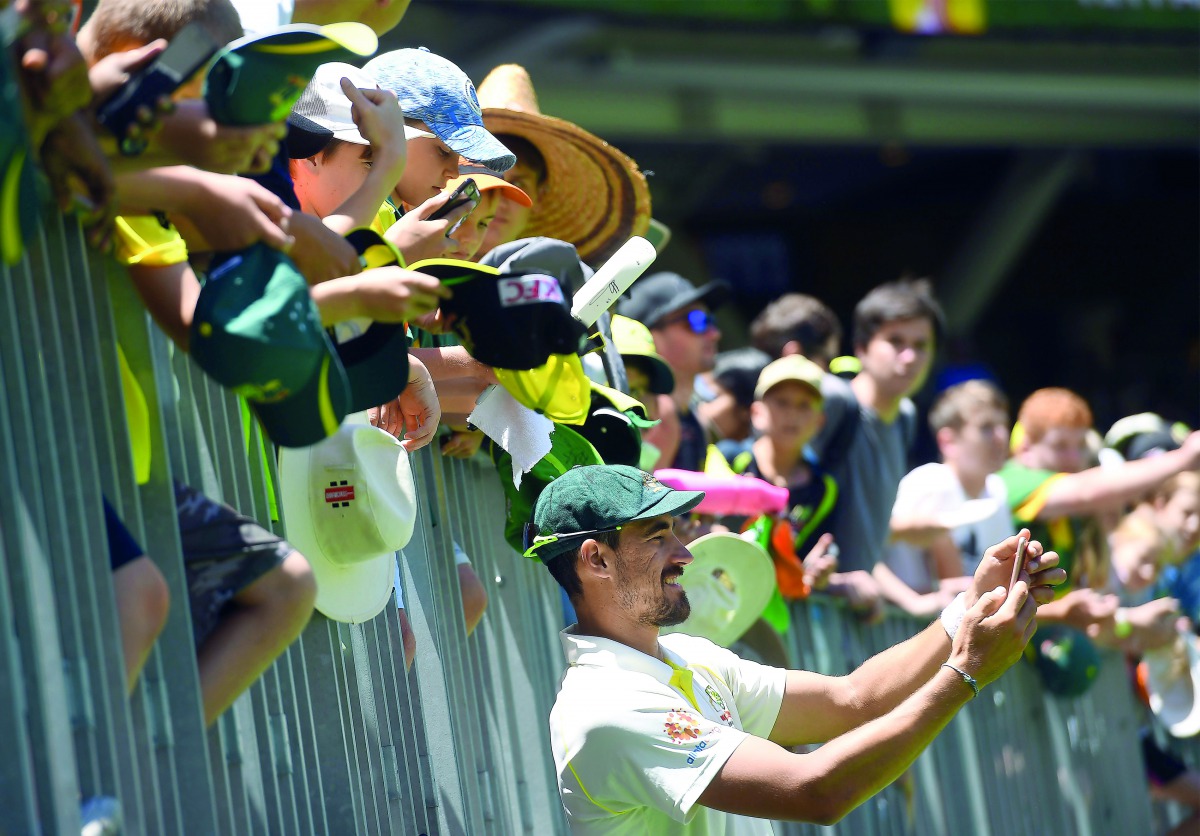 Australia's cricketer Mitchell Starc takes a selfie with fans during day five of the second cricket match between Australia and India in Perth on December 18, 2018. AFP / William West