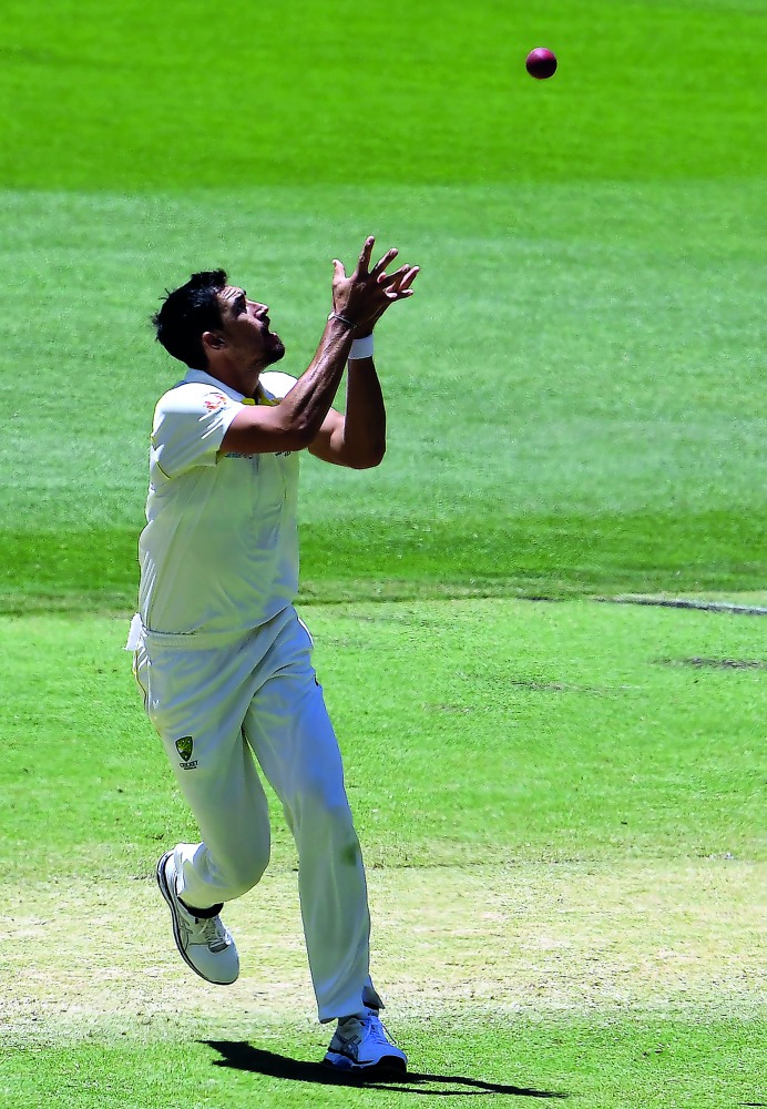 Australia's paceman Mitchell Starc takes a successful catch to dismiss India's batsman Umesh Yadav on his own bowling during day five of the second cricket match between Australia and India in Perth on December 18, 2018. AFP / William West
