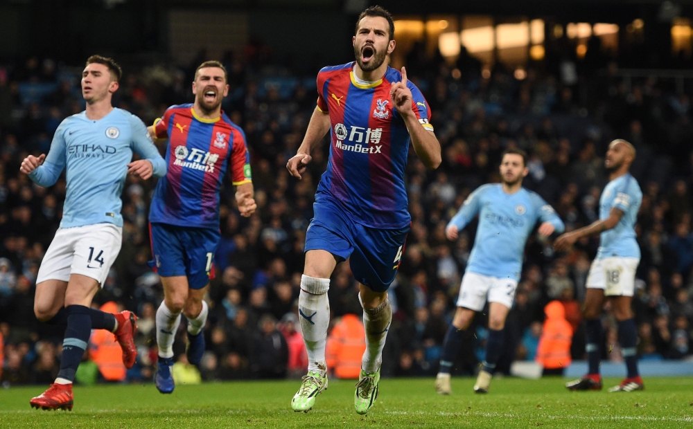 Crystal Palace's Serbian midfielder Luka Milivojevic (C) celebrates scoring their third goal from the penalty spot to extend their lead 1-3 during the English Premier League football match between Manchester City and Crystal Palace at the Etihad Stadium i
