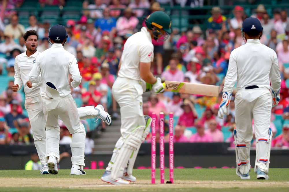 India's Kuldeep Yadav (L) celebrates with teammates after dismissing Australia's captain Tim Paine (C) during the third day's play of the fourth and final cricket Test between India and Australia at the Sydney Cricket Ground on January 5, 2019. (AFP / DAV