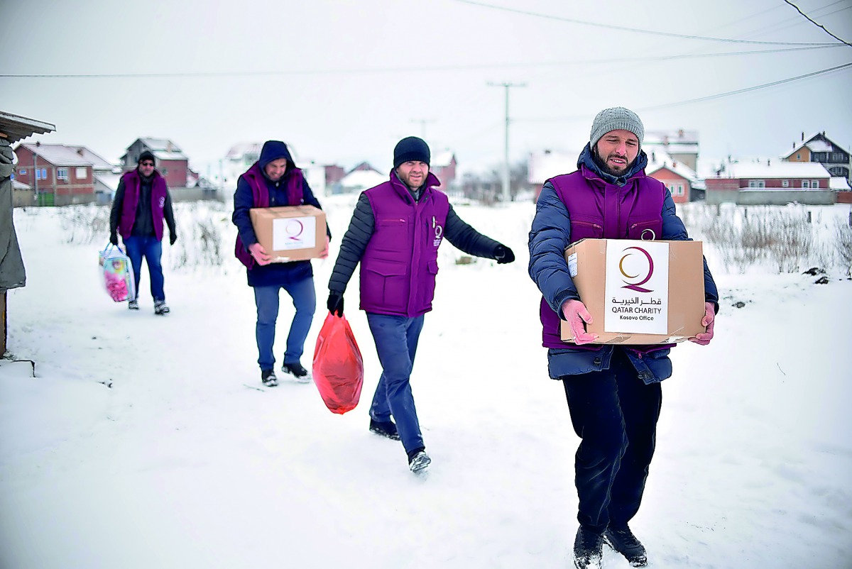 QC representatives delivering aid materials to poor people in Kosovo.