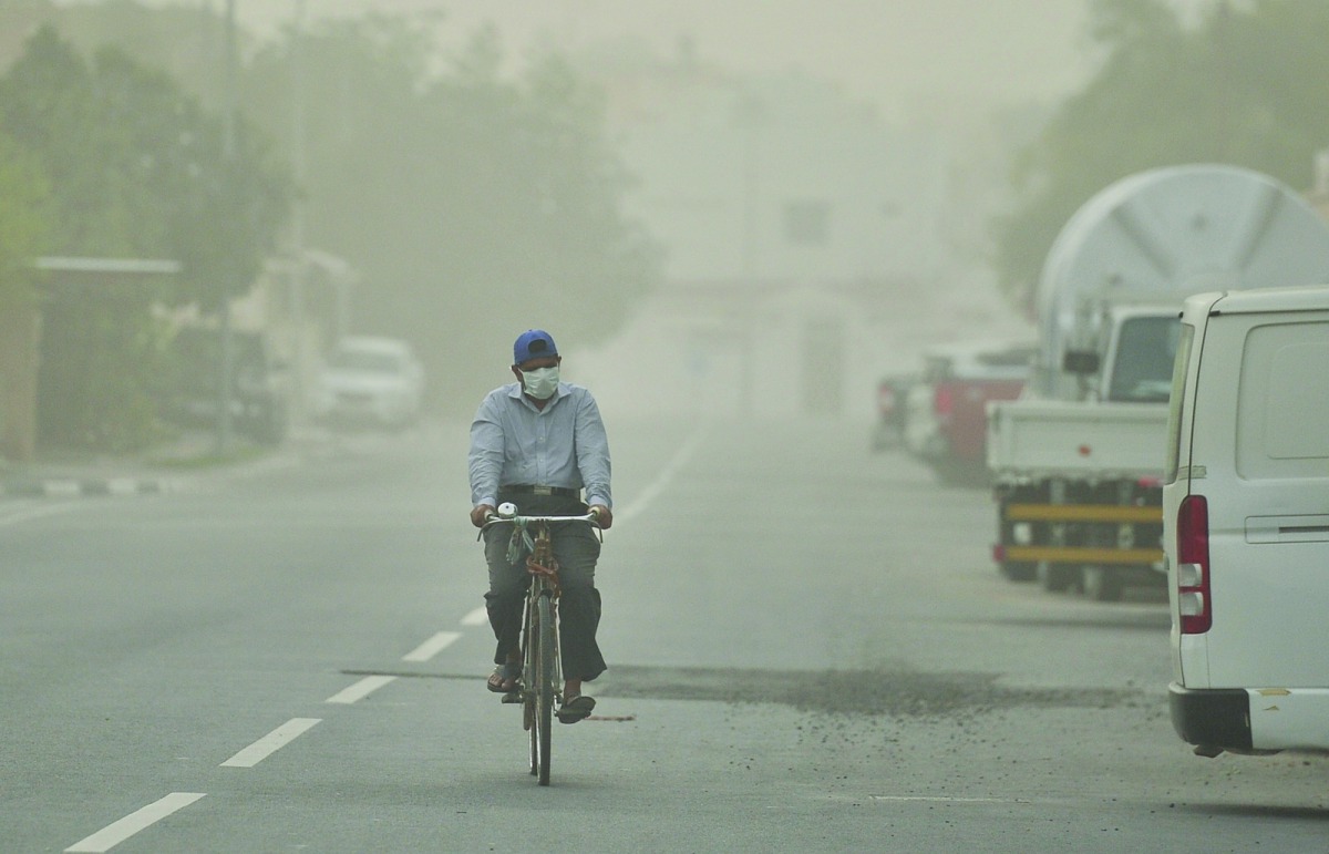 A cyclist braves through the dust storm in Al Sadd area yesterday. Pic: Baher Amin / The Peninsula