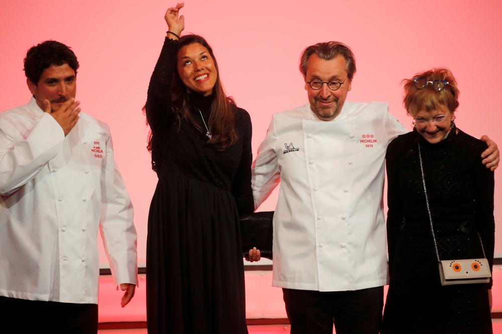 Newly awarded three-star Michelin chefs, Chef Laurent Petit, for his restaurant Le Clos des Sens in Annecy, and Chef Mauro Colagreco, for his restaurant Mirazur in Menton, react on stage with their wives during the Michelin Guide 2019 award ceremony in Pa