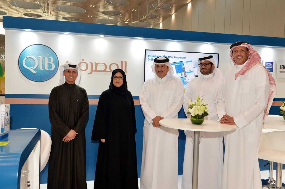 Sultan bin Rashid Al Khater, Undersecretary of the Ministry of Commerce and Industry; and Nama Center Acting Executive Director, in a group photo alongside QIB’s staff at the QIB’s pavilion at the exhibition.